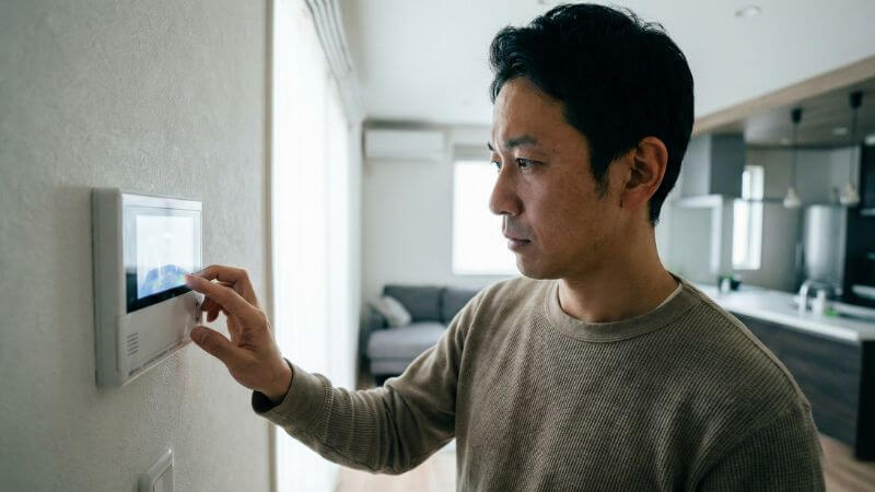 給湯器のリモコンでエラーコードを確認する男性